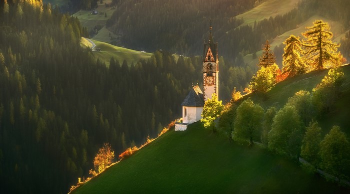 Church on a hill in a forest landscape at sunset