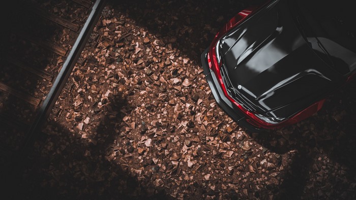 Black Mercedes C63 AMG on train tracks