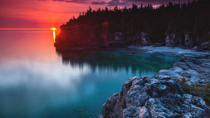 Sunset over rocky coast with clear water in Canada