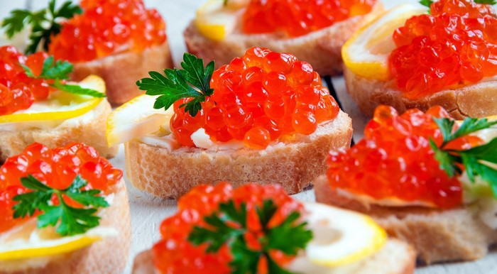 Appetizers with red caviar and lemon slices