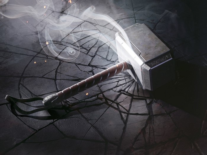 Mjolnir, Thor's Hammer, on cracked ground with smoke