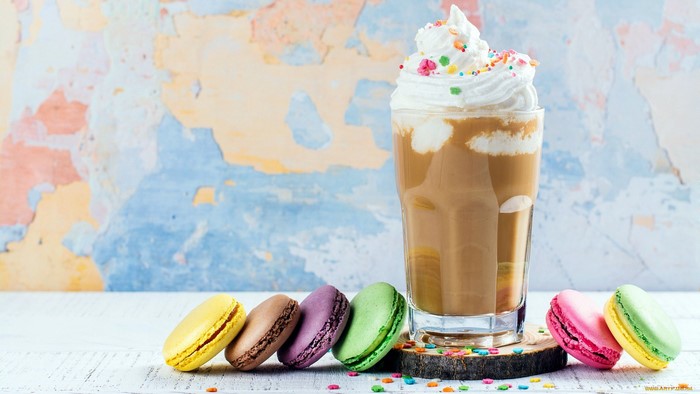Colorful macarons and a coffee drink with whipped cream