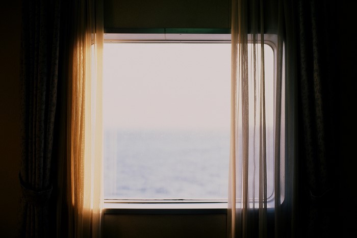 Train window with sunlight and curtains