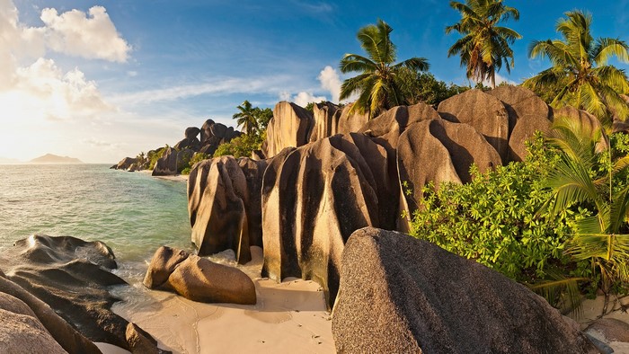 Tropical beach with granite boulders and palm trees