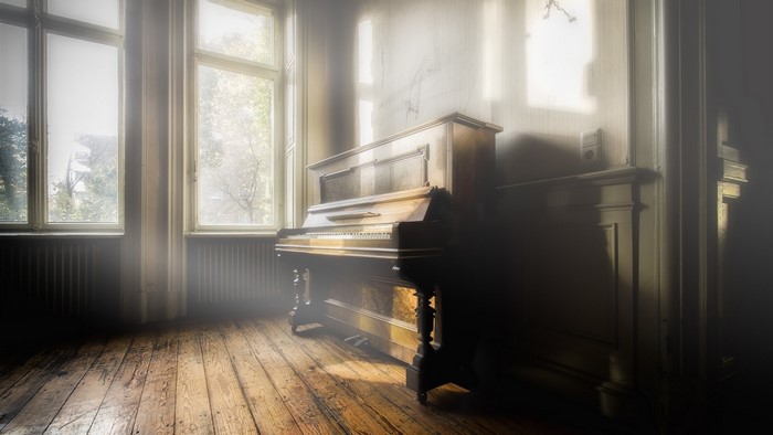 Antique upright piano in a sunlit room