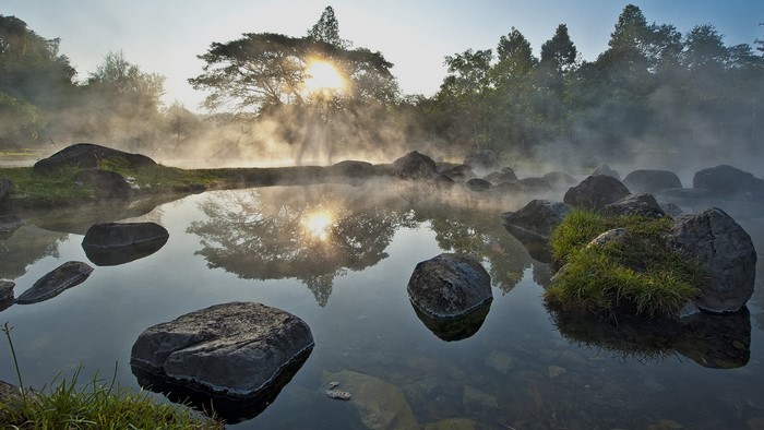 Sun rays through mist over hot springs in Chae Son National Park