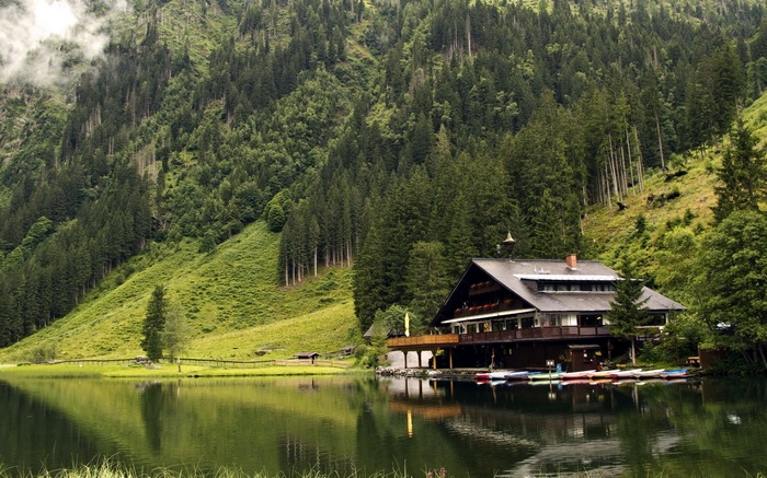 Building by a lake in a forested mountain