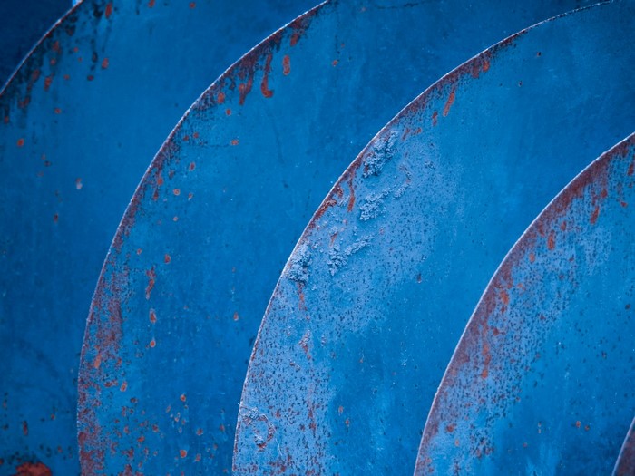 Abstract blue curved metal with rust