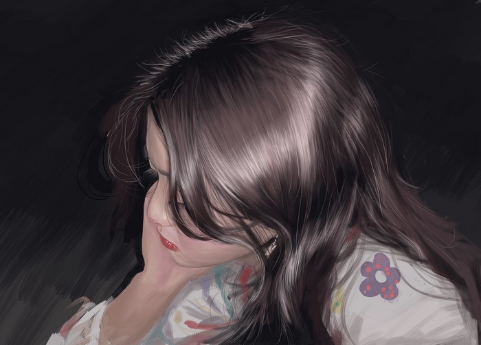 A young woman with dark hair looking down