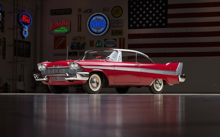 Red 1958 Plymouth Fury Christine in garage with American flag