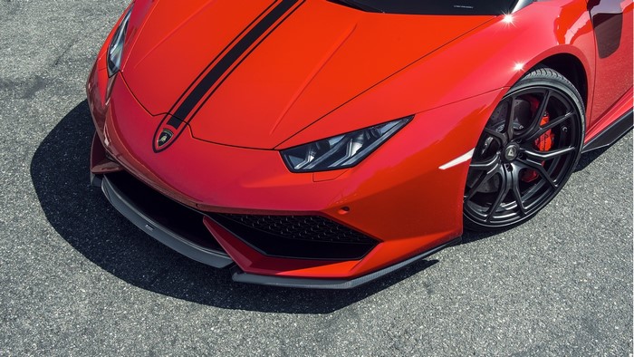 Red Lamborghini with black racing stripes on asphalt