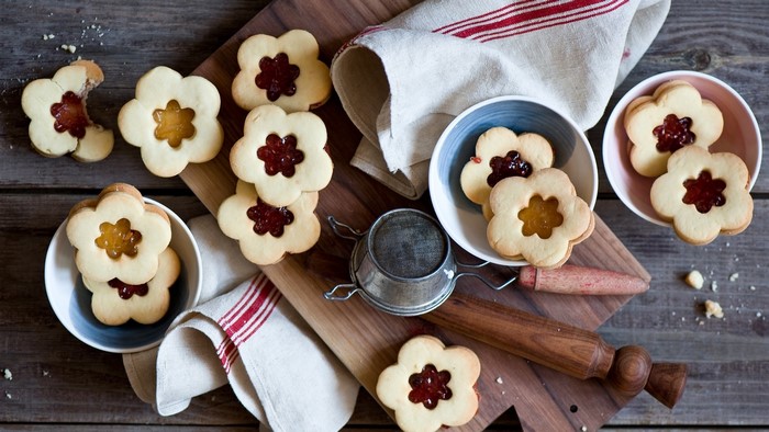 Flower-shaped jam cookies on a wooden table
