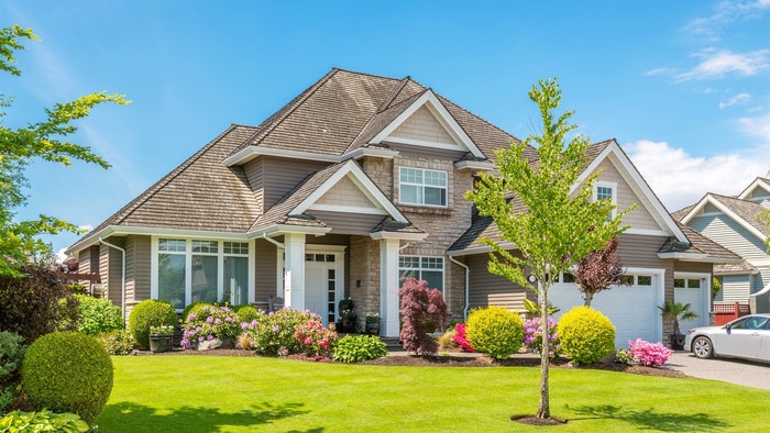 A large suburban house with a well-maintained lawn and garden