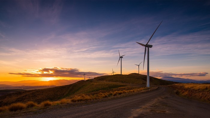 Wind farm on a hill at sunset in New Zealand