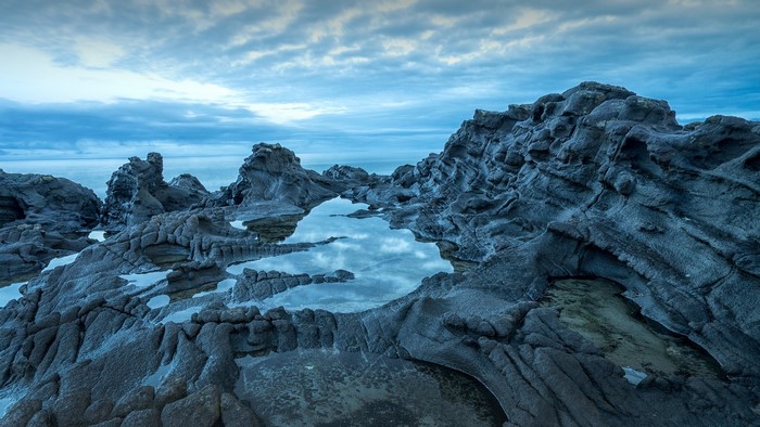 Rocky coastline with tide pools and cloudy sky