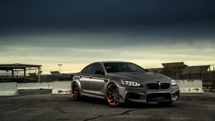 Silver BMW M6 with orange wheels on asphalt