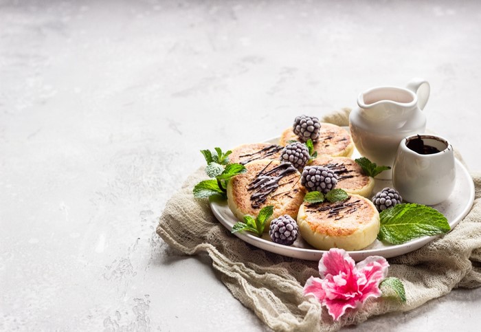 Syrniki with berries and chocolate drizzle