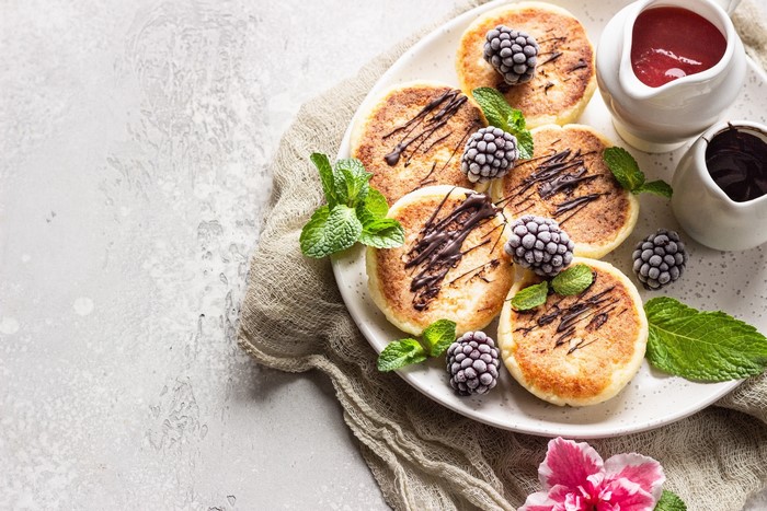 Syrniki with berries, chocolate, and mint