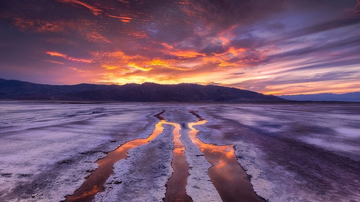 Sunset over Death Valley salt flats with mountain range