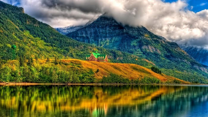 House on a hill overlooking a lake with mountains