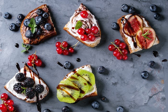 Assortment of fruit and cream toasts with berries and figs