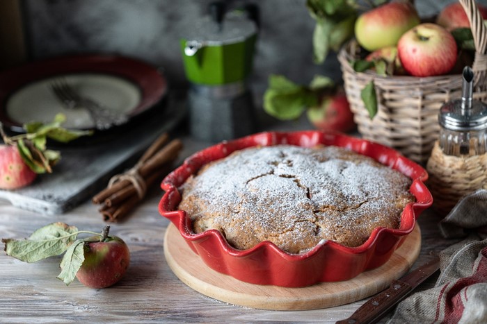 Apple pie with powdered sugar and cinnamon sticks