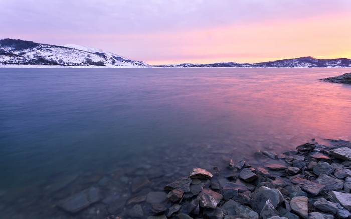 Lake and snow-covered mountains at sunset