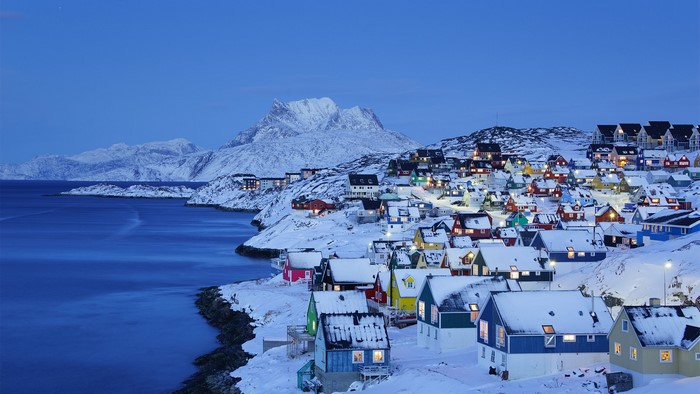 Colorful village on a snowy coast in Greenland at dusk