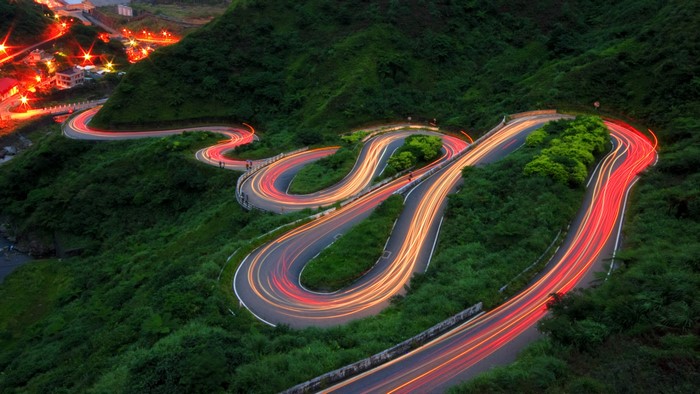 Long exposure of winding mountain road with car light trails in Taiwan