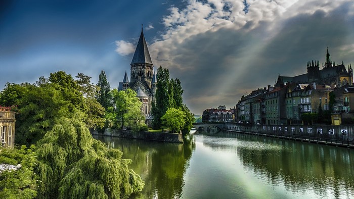 Cityscape with river and church in France