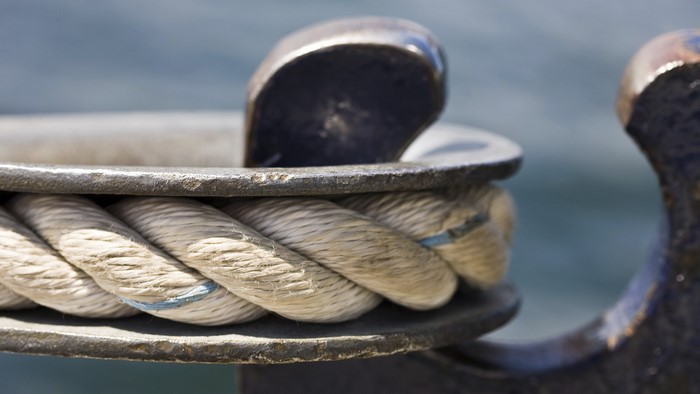 Rope tied to a metal cleat on a boat