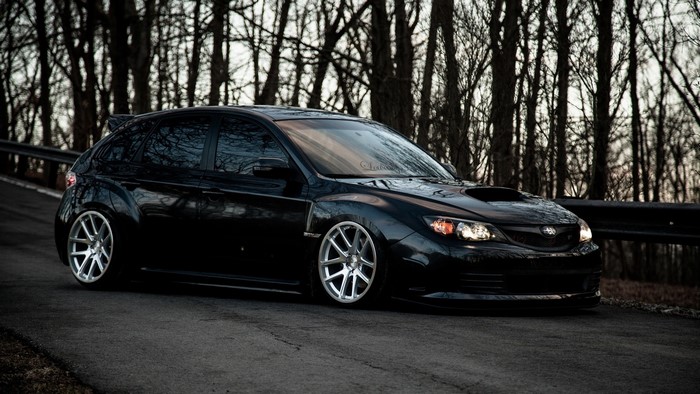 Black Subaru Impreza WRX STI hatchback on asphalt road