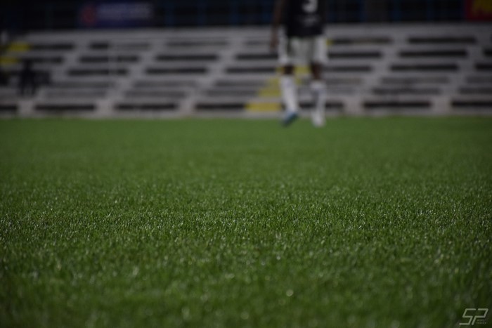 Soccer field with player and stadium seating