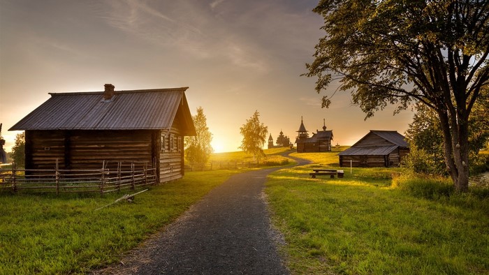 Wooden houses and churches at sunset with a road