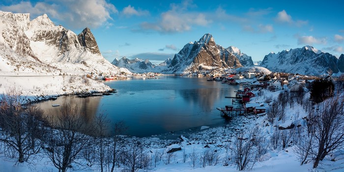 Snowy mountains and village by a lake in Reine, Norway