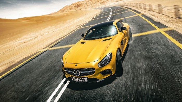 Yellow Mercedes-Benz car driving on a desert road