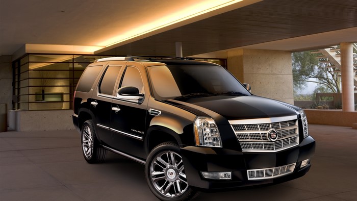 Black Cadillac Escalade parked under a modern building