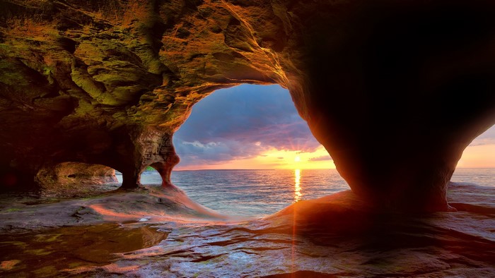 Cave opening overlooking Lake Superior at sunset