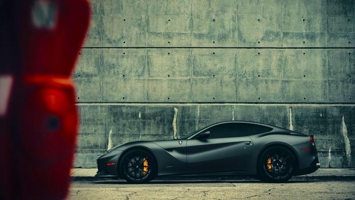 Ferrari F12berlinetta parked by a concrete wall