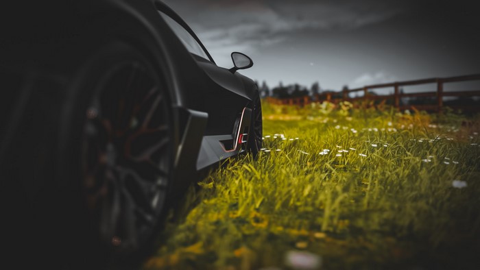 Bugatti Divo in a grassy field with a wooden fence