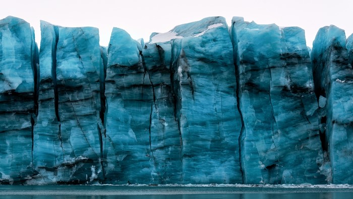 Massive blue glacier wall with dark streaks