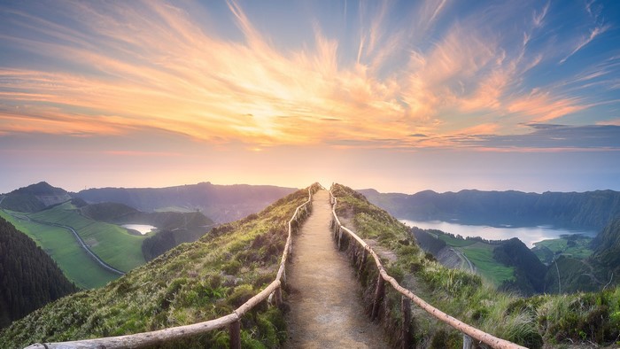 Path on a mountain ridge overlooking lakes at sunset