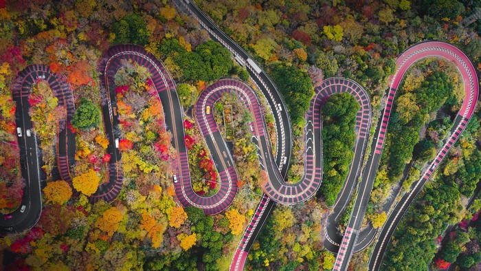 Aerial view of a winding mountain road in Japan during fall