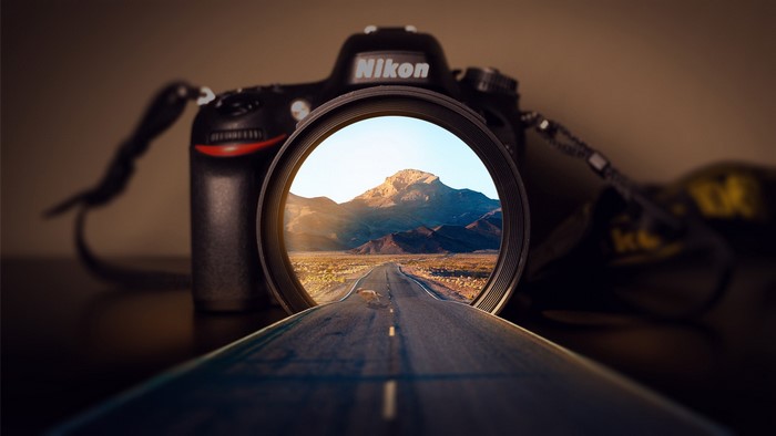 Nikon camera lens showing a desert road and mountain
