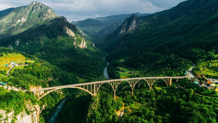 Arched bridge over a river valley in mountains