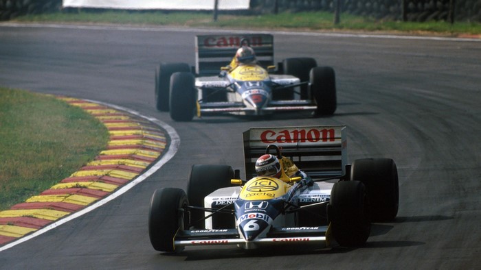 Two Formula 1 cars racing on a track, Canon sponsorship