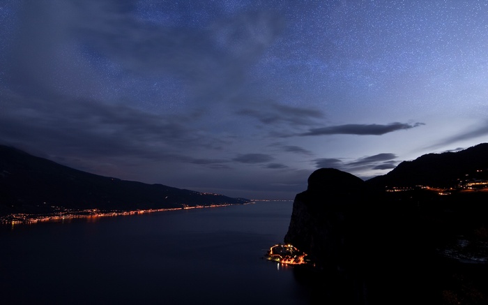 Night landscape with starry sky over a lake and mountains