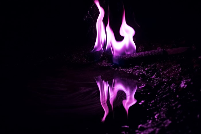 Purple fire reflecting on dark surface