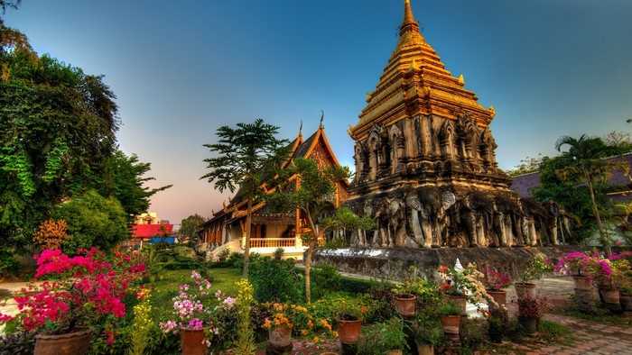 Buddhist temple with elephant statues and flowers in Thailand