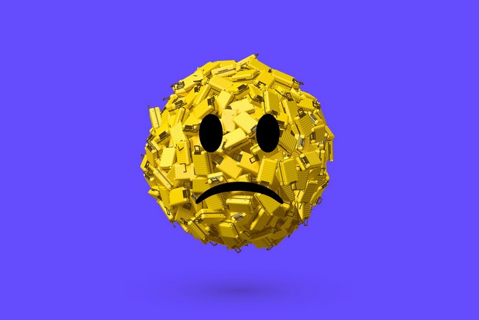 Sad smiley face made of yellow suitcases on a purple background